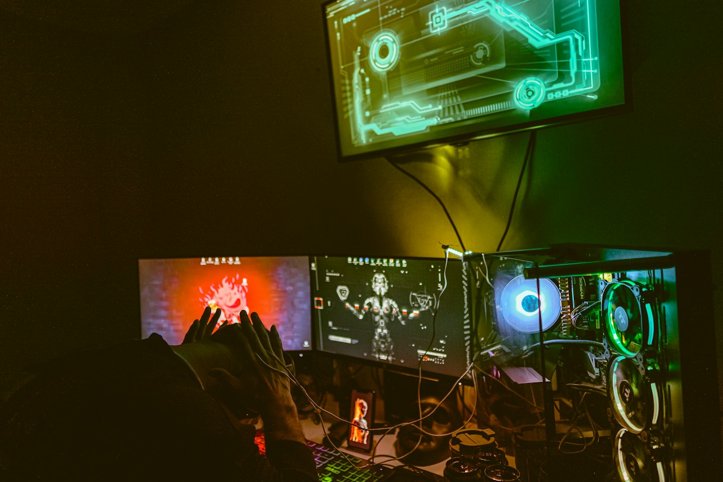 Person reacting to three-monitor gaming setup with RGB lighting.