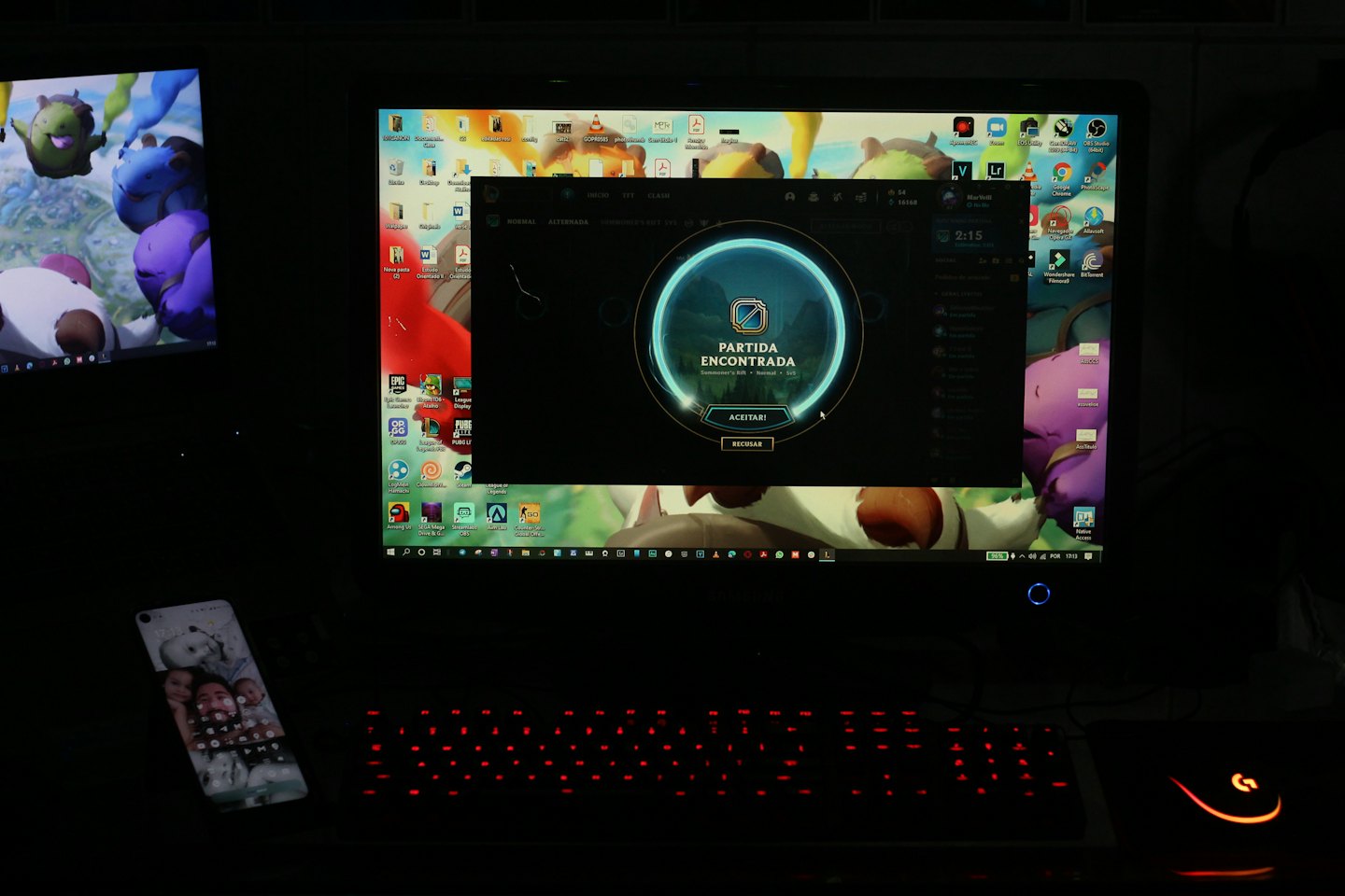 Gaming setup with dual monitors, keyboard, and smartphone.